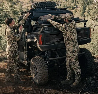 Hunters loading gear onto a Polaris XPEDITION cargo rack during a backcountry hunting trip